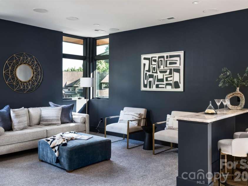 5620 Merry Mount Drive, Charlotte, NC 28226.  MLS# CAR4420251, YatesRealty ID 49600. Upper-level recreation lounge featuring dramatic navy walls, a raised bar counter with seating, and an integrated audio system.