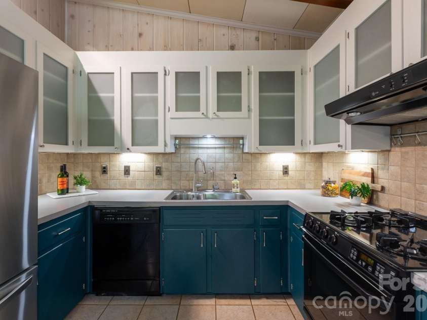 1526 Briarfield Drive, Charlotte, NC 28205.  MLS# CAR4422287, YatesRealty ID 49726. Glass-front cabinetry and tile backsplash.