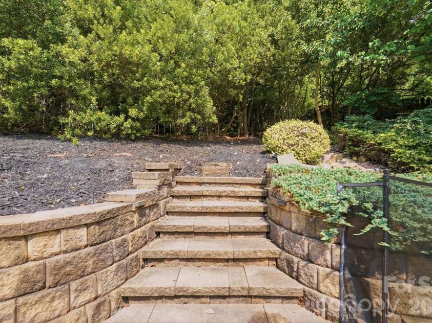 945 Rock Forest Way, Indian Land, SC 29707.  MLS# CAR4420908, YatesRealty ID 49783. Steps to waterfall feature and fire pit area