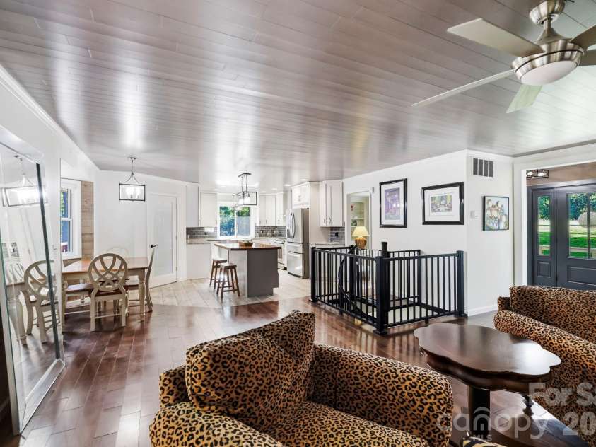 168 Country Lane, Mills River, NC 28759.  MLS# CAR4422309, YatesRealty ID 49874. A spacious, flowing layout connects the living room, dining area, and kitchen while showcasing the home’s custom finishes.