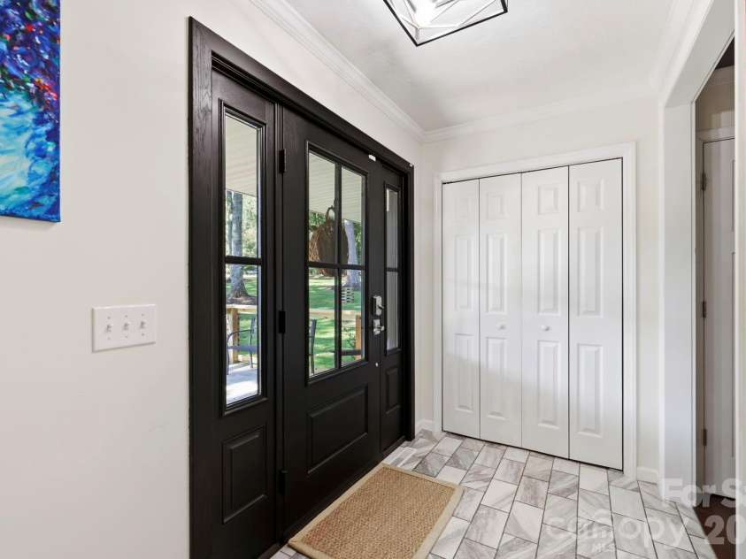 168 Country Lane, Mills River, NC 28759.  MLS# CAR4422309, YatesRealty ID 49874. Bright, updated entryway features tile flooring, crown molding, a stylish light fixture, and convenient coat closet.
