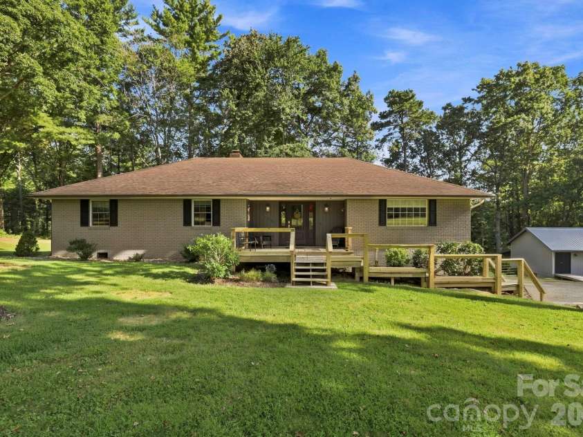 168 Country Lane, Mills River, NC 28759.  MLS# CAR4422309, YatesRealty ID 49874. Classic brick exterior with a peaceful wooded setting, spacious front yard, and inviting covered entry.