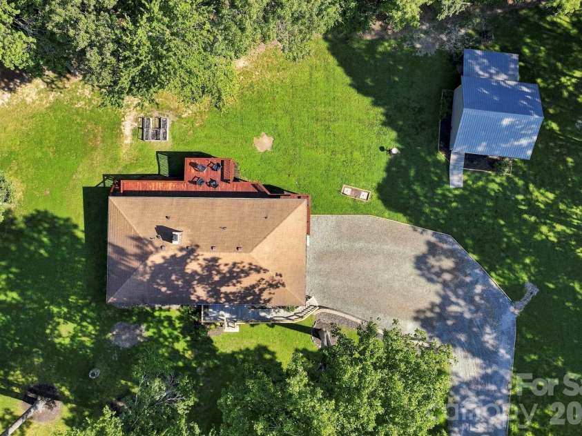 168 Country Lane, Mills River, NC 28759.  MLS# CAR4422309, YatesRealty ID 49874. Overhead view highlights the home's spacious grounds, large parking area, rear deck, and detached outbuilding.