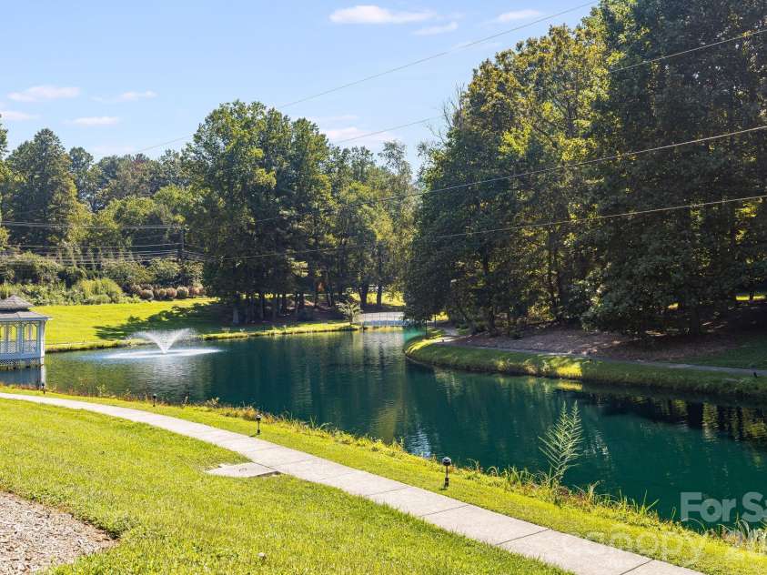 212 Carriage Springs Way, Hendersonville, NC 28791.  MLS# CAR4420645, YatesRealty ID 49923. Community pond with walking trails around it.
