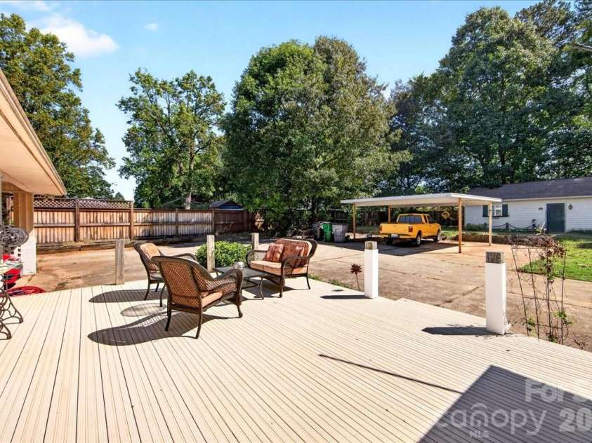 1442 Plumcrest Drive, Charlotte, NC 28216.  MLS# CAR4422358, YatesRealty ID 49987. Back deck looking toward metal carport and workshop