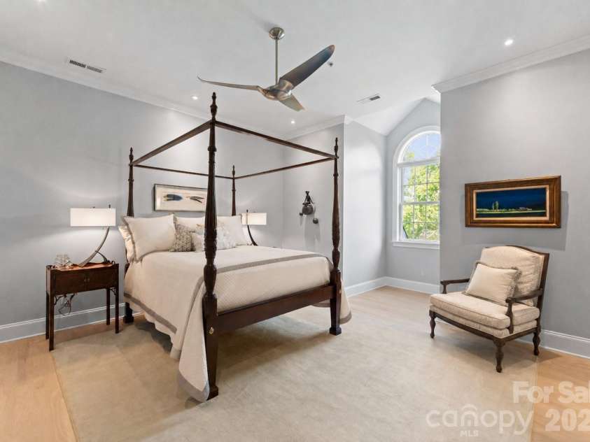 974 Queens Road, Charlotte, NC 28207.  MLS# CAR4413389, YatesRealty ID 50053. A gracious guest bedroom combines classic elegance with comfort, featuring a beautiful arched window, warm hardwood floors, and more than enough room for a cozy sitting area.