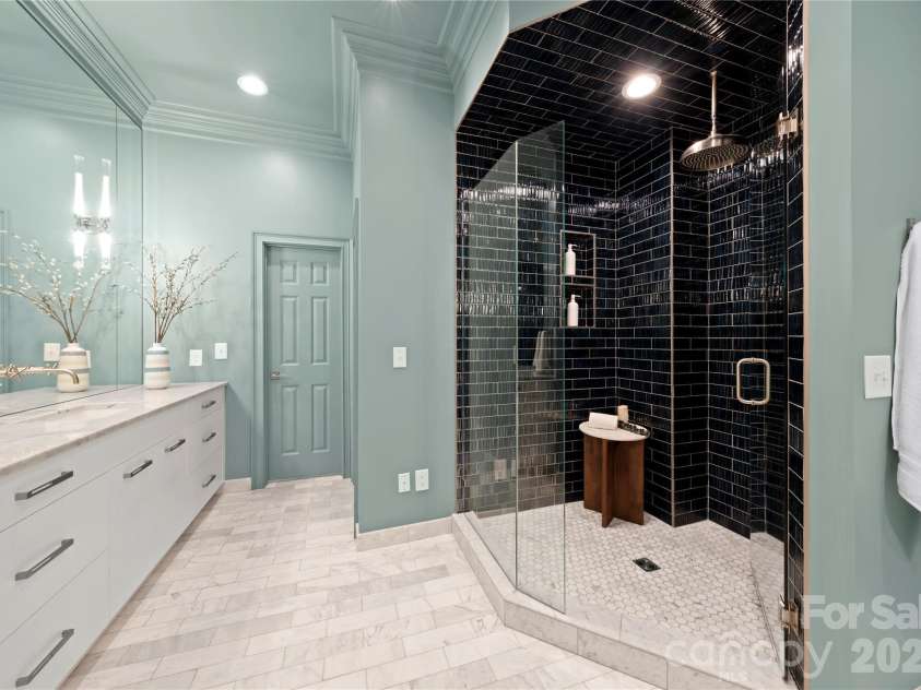 974 Queens Road, Charlotte, NC 28207.  MLS# CAR4413389, YatesRealty ID 50053. Dramatic Walk-In Shower — with an oversized rain showerhead, frameless glass enclosure and gloss dark subway tiles create a striking boutique-spa feel within the luxurious primary bath.