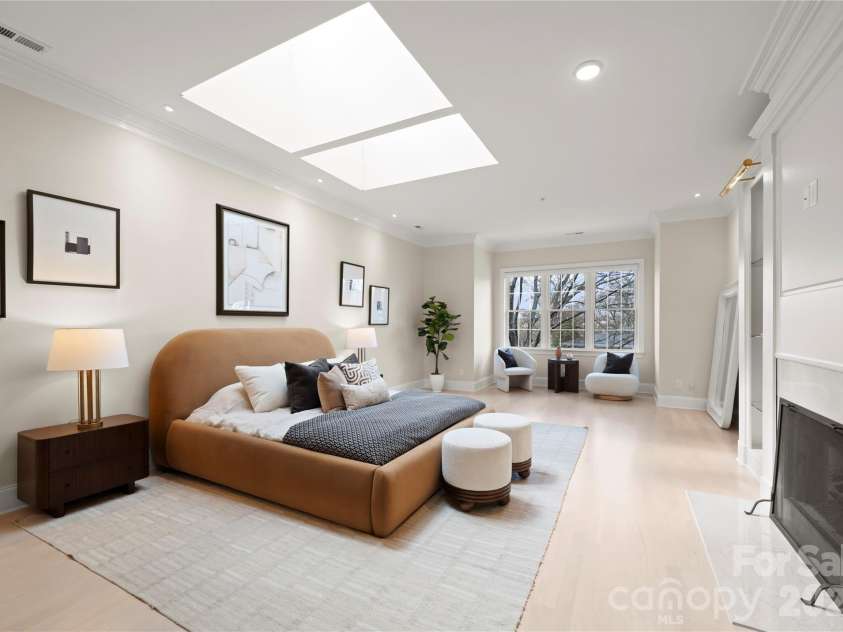 974 Queens Road, Charlotte, NC 28207.  MLS# CAR4413389, YatesRealty ID 50053. Light-Filled Primary Sanctuary — Oversized skylights bring beautiful natural light to this serene primary suite featuring a your private fireplace, sitting area with spectacular tree-top views and warm hardwood floors.
