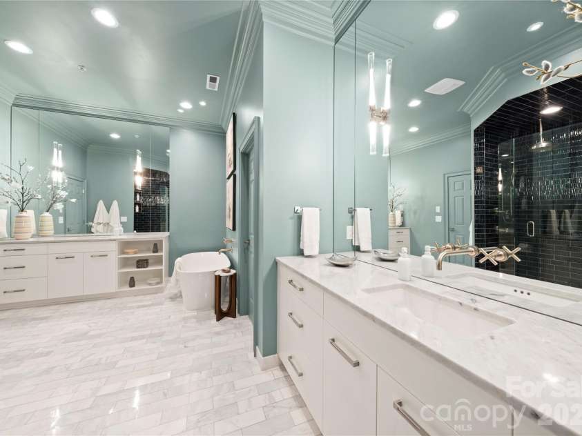 974 Queens Road, Charlotte, NC 28207.  MLS# CAR4413389, YatesRealty ID 50053. Spa-Inspired Primary Bath — With marble floors, dual vanities, expansive mirrors, a freestanding soaking tub and dramatic dark-tiled walk-in shower.