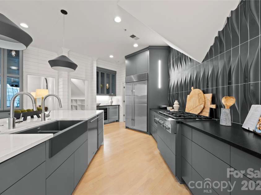 974 Queens Road, Charlotte, NC 28207.  MLS# CAR4413389, YatesRealty ID 50053. The dramatic dimensional backsplash and streamlined cabinetry create a bold, beautifully finished cooking space for the chef and family or guests to enjoy.