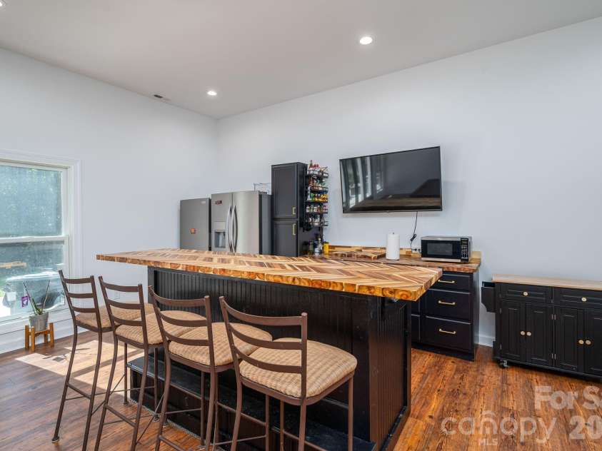 1551 Brevard Place Road, Iron Station, NC 28080.  MLS# CAR4422440, YatesRealty ID 50132. Basement entertaining area with moveable bar, countertop seating and additional storage.