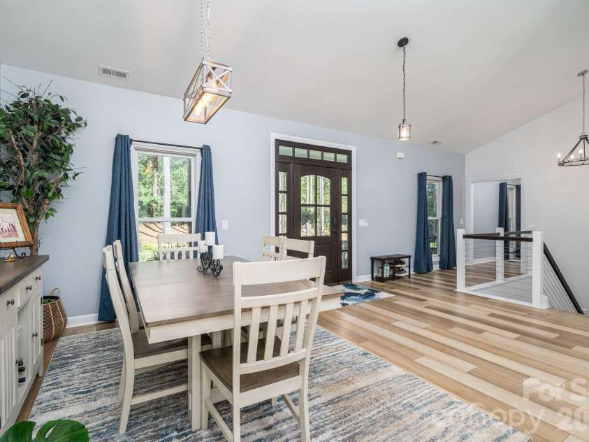 1551 Brevard Place Road, Iron Station, NC 28080.  MLS# CAR4422440, YatesRealty ID 50132. Dining area featuring vaulted ceilings, abundant natural light, and easy access to the covered front porch.