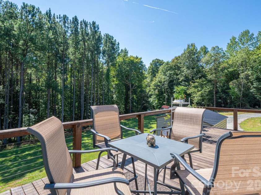 1551 Brevard Place Road, Iron Station, NC 28080.  MLS# CAR4422440, YatesRealty ID 50132. Imaging enjoying dinner or your morning coffee on the spacious upper-deck while taking in the peaceful, wooded surroundings.