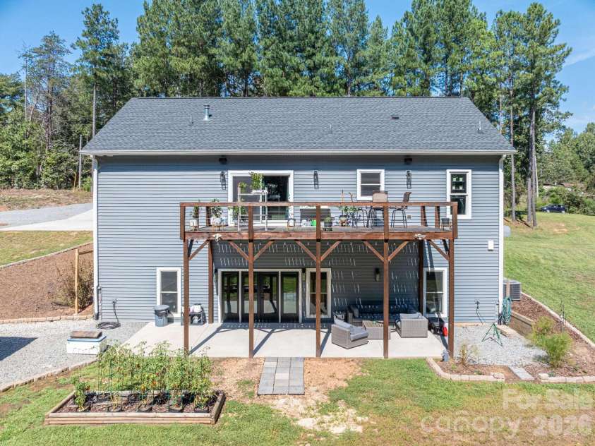 1551 Brevard Place Road, Iron Station, NC 28080.  MLS# CAR4422440, YatesRealty ID 50132. Rear exterior featuring upper-level deck and covered patio overlooking the backyard.