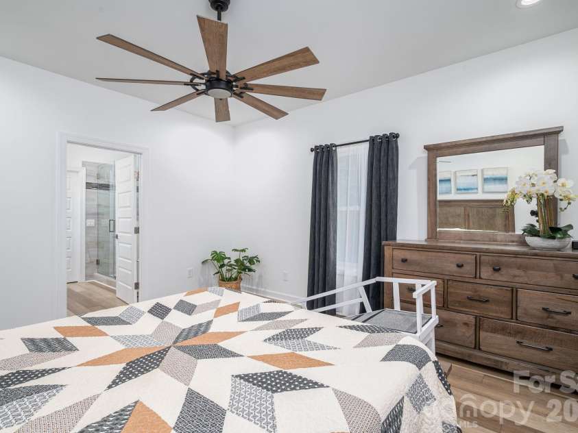 1551 Brevard Place Road, Iron Station, NC 28080.  MLS# CAR4422440, YatesRealty ID 50132. Spacious split main level primary suite featuring a private en-suite bathroom and walk-in closet.