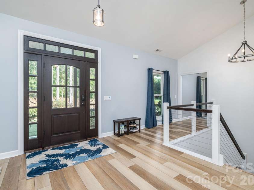 1551 Brevard Place Road, Iron Station, NC 28080.  MLS# CAR4422440, YatesRealty ID 50132. Welcome front entry featuring sidelights, transom windows, vaulted ceilings, and open staircase leading to the finished walkout basement.