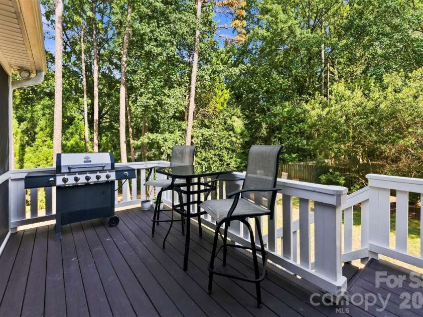 7337 Versailles Lane, Charlotte, NC 28277.  MLS# CAR4418758, YatesRealty ID 50195. Restained in July, the adjoining deck provides an inviting setting for grilling, dining, and enjoying the private surroundings