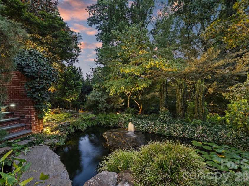 2115 Foxcroft Woods Lane, Charlotte, NC 28211.  MLS# CAR4418029, YatesRealty ID 50200. Koi pond at twilight with landscape lighting.