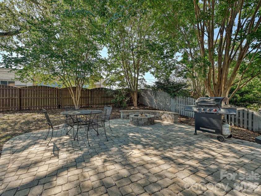 19706 Valiant Way, Cornelius, NC 28031.  MLS# CAR4423741, YatesRealty ID 50358. Large backyard patio creates an inviting outdoor entertaining area surrounded by trees and a fenced yard.