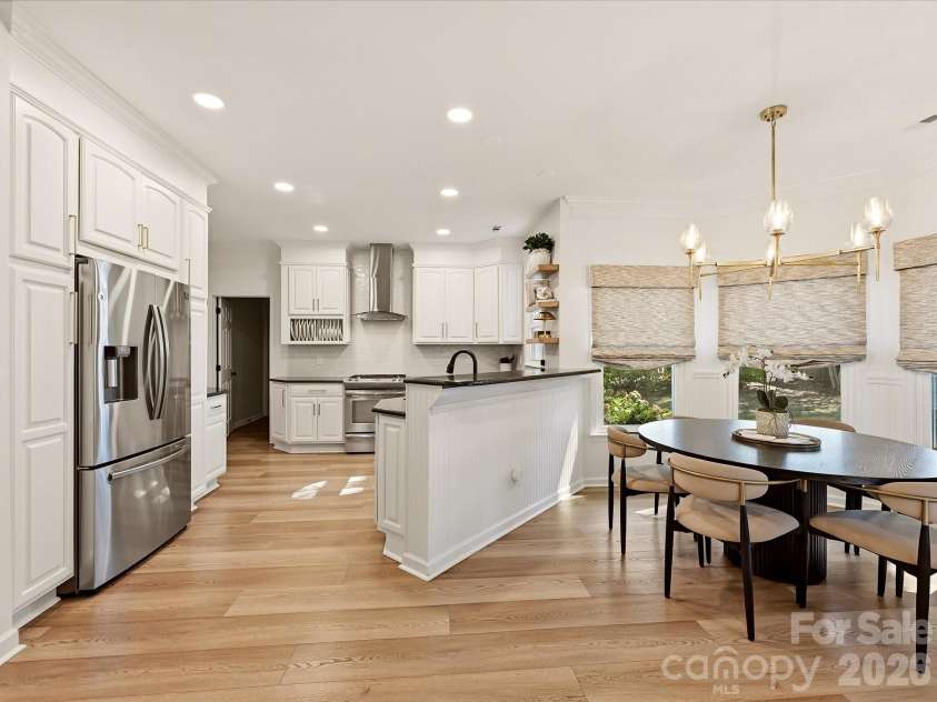 19706 Valiant Way, Cornelius, NC 28031.  MLS# CAR4423741, YatesRealty ID 50358. Updated kitchen features a spacious peninsula with breakfast bar seating, abundant cabinetry, modern finishes, and an open layout overlooking the living area.
