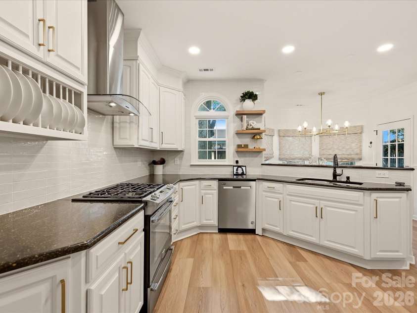 19706 Valiant Way, Cornelius, NC 28031.  MLS# CAR4423741, YatesRealty ID 50358. Updated kitchen showcases crisp cabinetry, tile backsplash, generous workspace, and a peninsula with breakfast bar seating ideal for casual dining and entertaining.