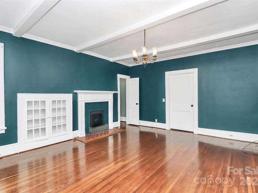 106 Patrick Street, Gastonia, NC 28054.  MLS# CAR4211369, YatesRealty ID 5055. 3rd view of the primary bedroom with ceiling beams, a fireplace & built ins.