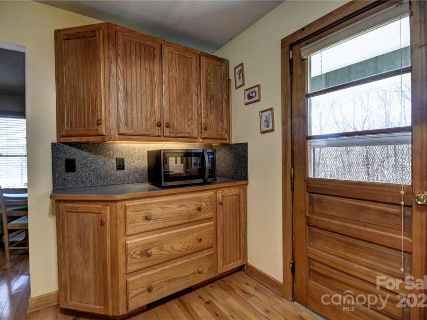 119 Pleasant Hill Circle, Waynesville, NC 28786.  MLS# CAR4325217, YatesRealty ID 506. More kitchen cabinets with a microwave oven, door is to the back porch/deck