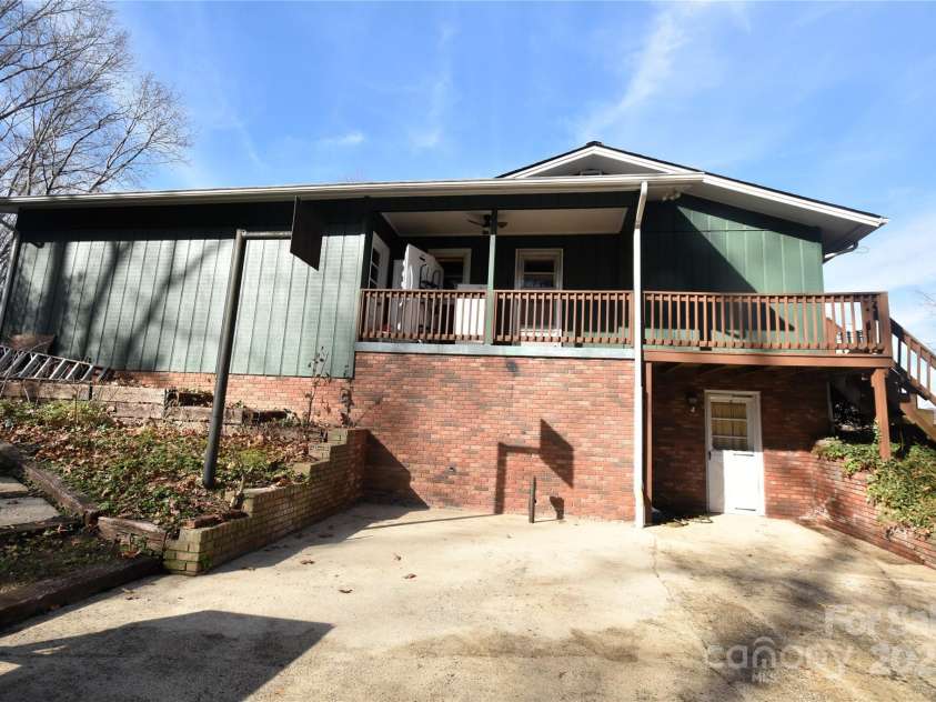 119 Pleasant Hill Circle, Waynesville, NC 28786.  MLS# CAR4325217, YatesRealty ID 506. Side View of home with porch/deck off the main level kitchen, the door below the deck is to the basement, large concrete patio for entertaining