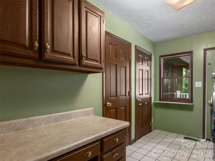 440 Sondley Woods Place, Asheville, NC 28805.  MLS# CAR4423407, YatesRealty ID 50704. Large Laundry room with storage and opens to deck
