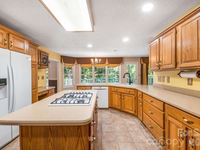 13 Lowry Lane, Weaverville, NC 28787.  MLS# CAR4415194, YatesRealty ID 50910. The kitchen has space for a breakfast table with windows looking onto the deck.