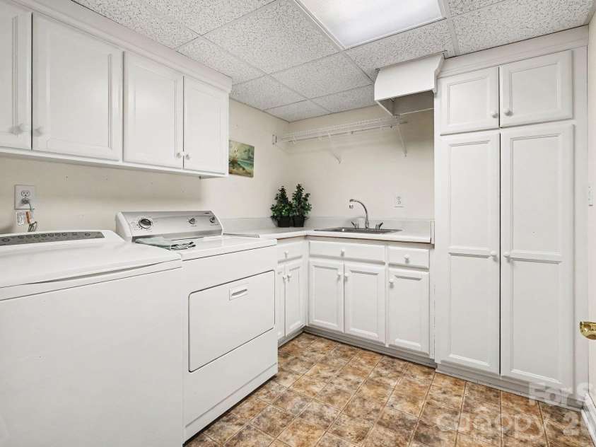 746 Grandview Drive, Concord, NC 28025.  MLS# CAR4434570, YatesRealty ID 5093. Spacious laundry room with sink, chute, and additional storage cabinets