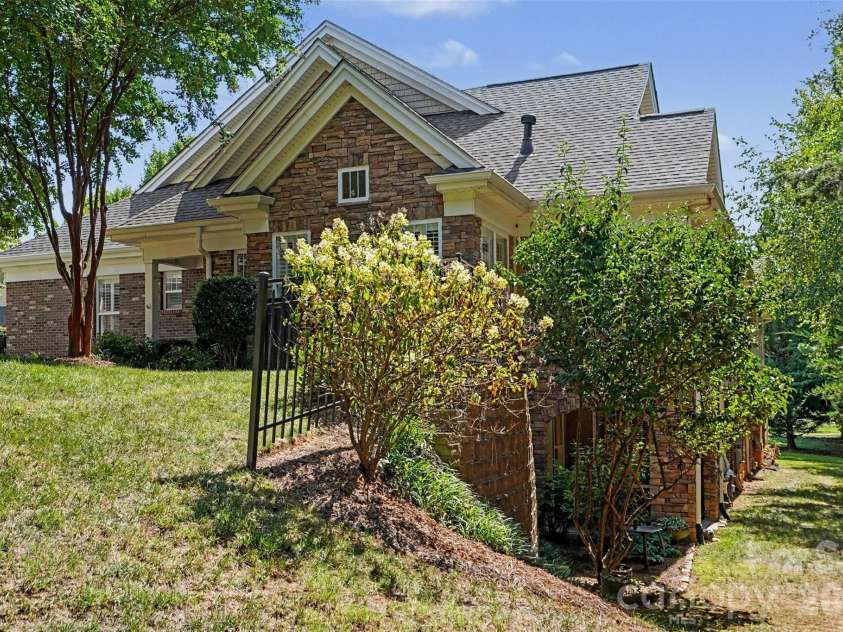 2604 Bellasera Way, Matthews, NC 28105.  MLS# CAR4425096, YatesRealty ID 51142. Side of property including walk-out patio on lower level