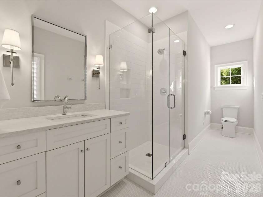 18717 Square Sail Road, Cornelius, NC 28031.  MLS# CAR4424933, YatesRealty ID 51420. Bedroom 4 ensuite bath features a frameless glass shower, spacious vanity with stone countertop, crisp tile finishes, and abundant natural light.