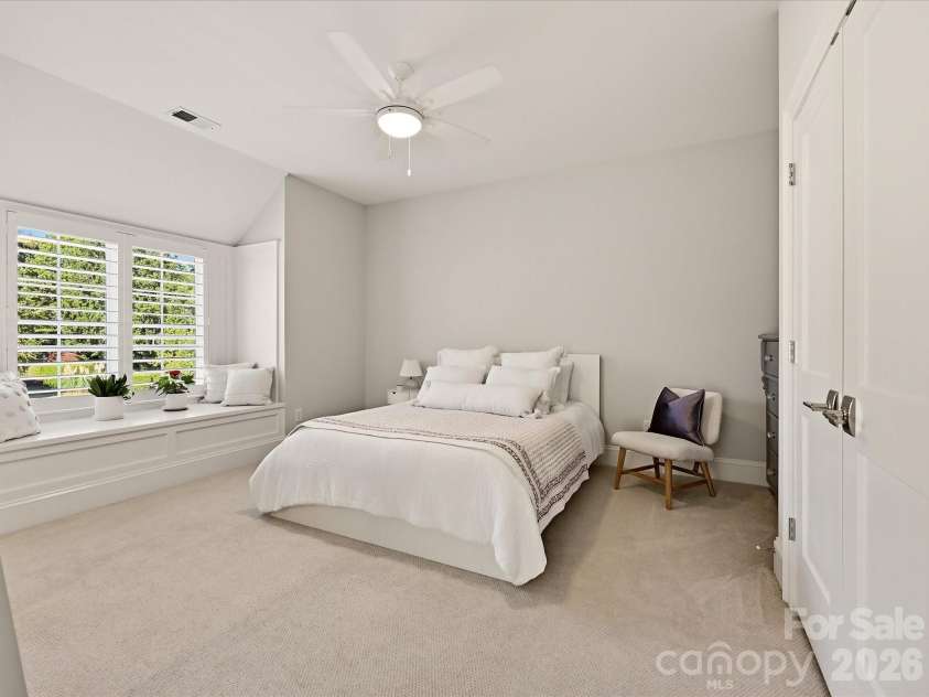 18717 Square Sail Road, Cornelius, NC 28031.  MLS# CAR4424933, YatesRealty ID 51420. Bedroom 4 offers a spacious, light-filled retreat with soft neutral finishes, a charming window seat, and ample room for comfortable furnishings.