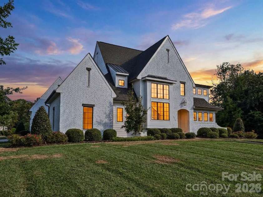 18717 Square Sail Road, Cornelius, NC 28031.  MLS# CAR4424933, YatesRealty ID 51420. Impressive exterior showcases timeless white-brick architecture, manicured landscaping, and a spacious two-car garage with a broad driveway for convenient parking and access.