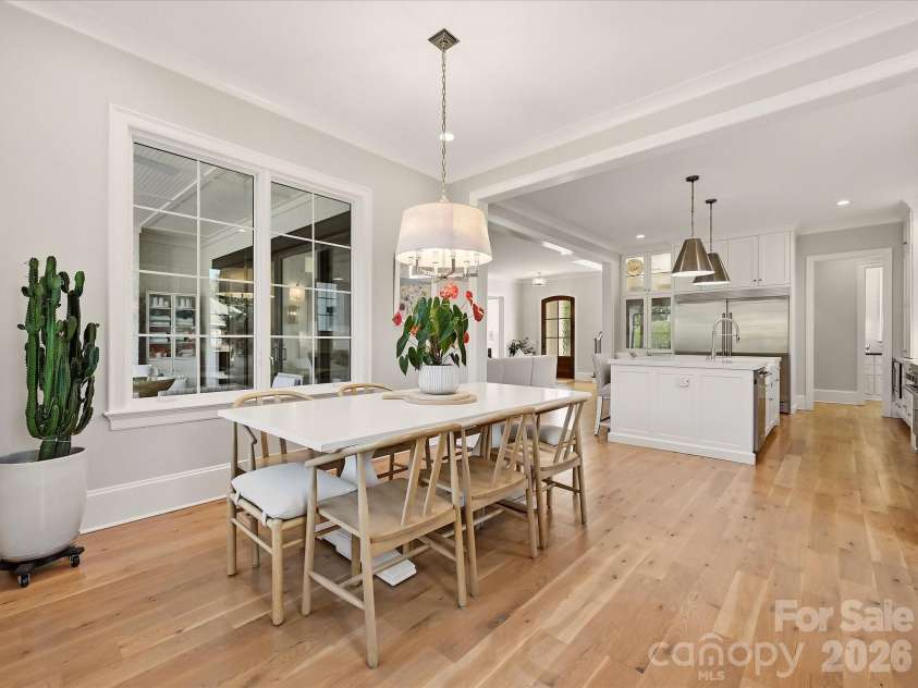 18717 Square Sail Road, Cornelius, NC 28031.  MLS# CAR4424933, YatesRealty ID 51420. The kitchen flows effortlessly into a sunlit breakfast area, where expansive windows, hardwood floors, and views toward the covered patio create an inviting setting for casual dining.