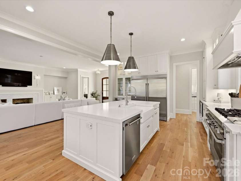 18717 Square Sail Road, Cornelius, NC 28031.  MLS# CAR4424933, YatesRealty ID 51420. The kitchen flows effortlessly into a sunlit breakfast area, where expansive windows, hardwood floors, and views toward the covered patio create an inviting setting for casual dining.
