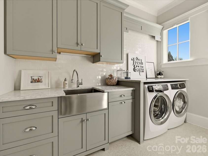 18717 Square Sail Road, Cornelius, NC 28031.  MLS# CAR4424933, YatesRealty ID 51420. Well-appointed laundry room features custom cabinetry, generous counter space, a utility sink, and convenient built-in storage for added everyday functionality.