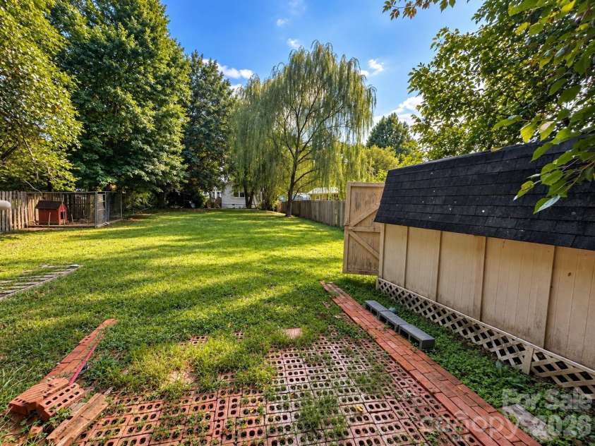 4711 Summit Avenue, Greensboro, NC 27405.  MLS# CAR4425186, YatesRealty ID 51545. Backyard with Shed and Willow Trees