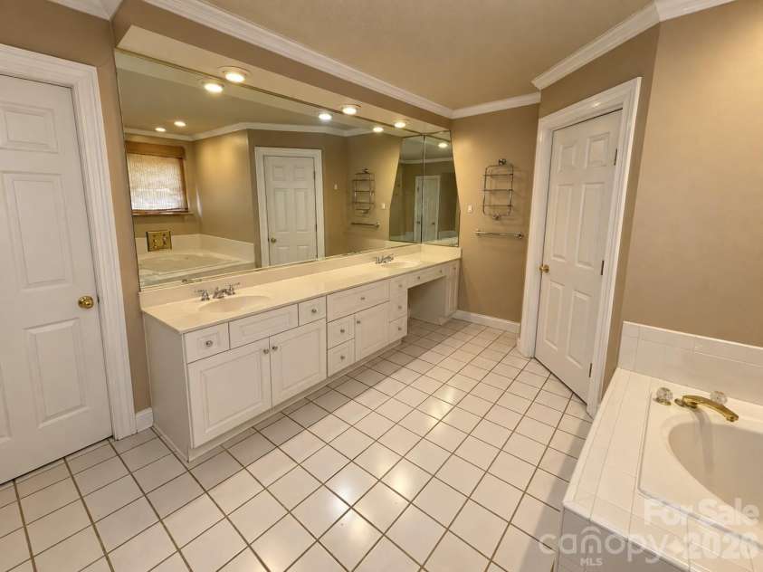 4711 Summit Avenue, Greensboro, NC 27405.  MLS# CAR4425186, YatesRealty ID 51545. Beige Bathroom with Mirrored Vanity