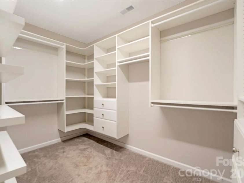 144 Steeplechase Avenue, Mooresville, NC 28117.  MLS# CAR4424163, YatesRealty ID 51592. Spacious primary closet with a custom built in organization system.