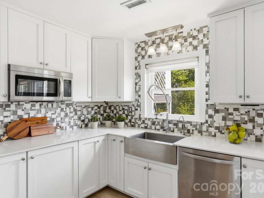 3022 Point Clear Drive, Tega Cay, SC 29708.  MLS# CAR4423199, YatesRealty ID 51620. Apron-front stainless sink overlooking the backyard—because even doing the dishes is better with a great view!