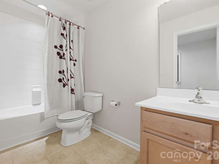 3341 Linetender Drive, Davidson, NC 28036.  MLS# CAR4425656, YatesRealty ID 51645. Guest Bathroom: Full bathroom featuring a maple vanity, tile flooring, and tub/shower combination.