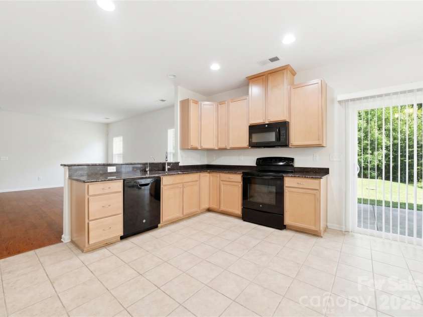 3341 Linetender Drive, Davidson, NC 28036.  MLS# CAR4425656, YatesRealty ID 51645. Kitchen: Well-appointed kitchen featuring granite countertops, 42-inch maple cabinetry, recessed lighting, and abundant workspace with direct access to the backyard patio.