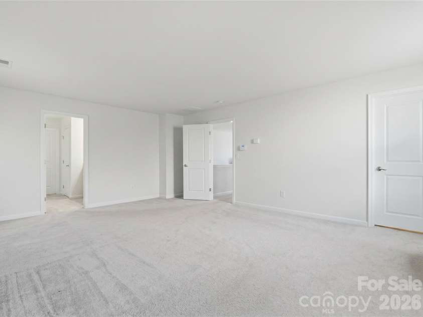 3341 Linetender Drive, Davidson, NC 28036.  MLS# CAR4425656, YatesRealty ID 51645. Primary Bedroom: Additional view showcasing the spacious layout and furniture flexibility. Large walk-in closet off the bedroom.