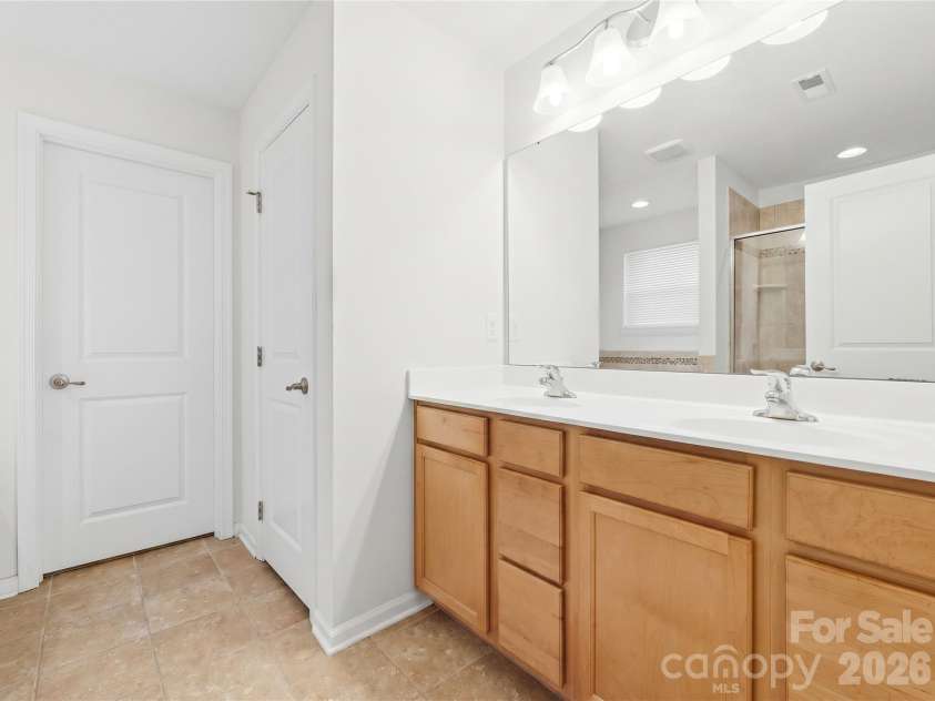 3341 Linetender Drive, Davidson, NC 28036.  MLS# CAR4425656, YatesRealty ID 51645. Primary Ensuite Bathroom: Primary bath featuring a dual-sink maple vanity with direct access to the secondary walk-in closet.