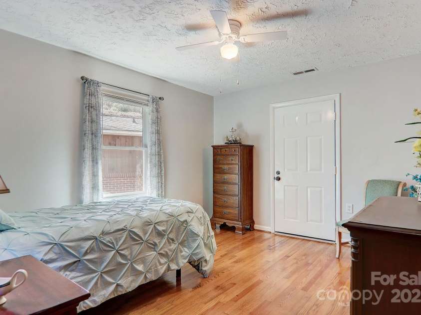 2541 Dellwood Road, Waynesville, NC 28786.  MLS# CAR4243546, YatesRealty ID 5168. The home has a second bedroom with private bath, that features refinished hardwood floors and an exterior door out to the back deck for late evening relaxation.