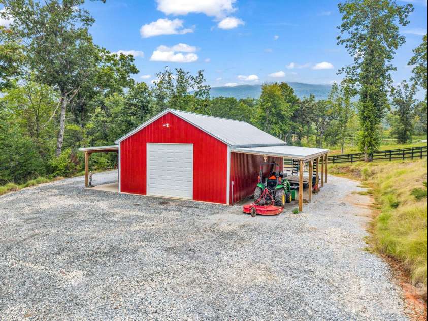 2255 Lake Adger Road, Mill Spring, NC 28756.  MLS# CAR4426062, YatesRealty ID 51693. Equipment building with two overhead doors, covered storage on the right