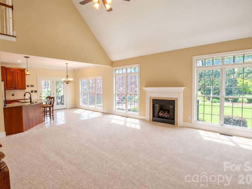 1927 Windmere Drive, Monroe, NC 28110.  MLS# CAR4418853, YatesRealty ID 51747. Large great room with gas fireplace, floor to ceiling windows, vaulted ceilings, and a ceiling fan