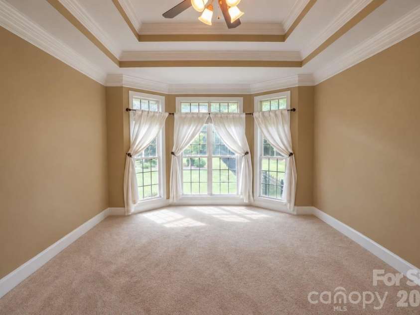 1927 Windmere Drive, Monroe, NC 28110.  MLS# CAR4418853, YatesRealty ID 51747. Main floor primary suite with sitting area, coffered ceiling, and wall of windows